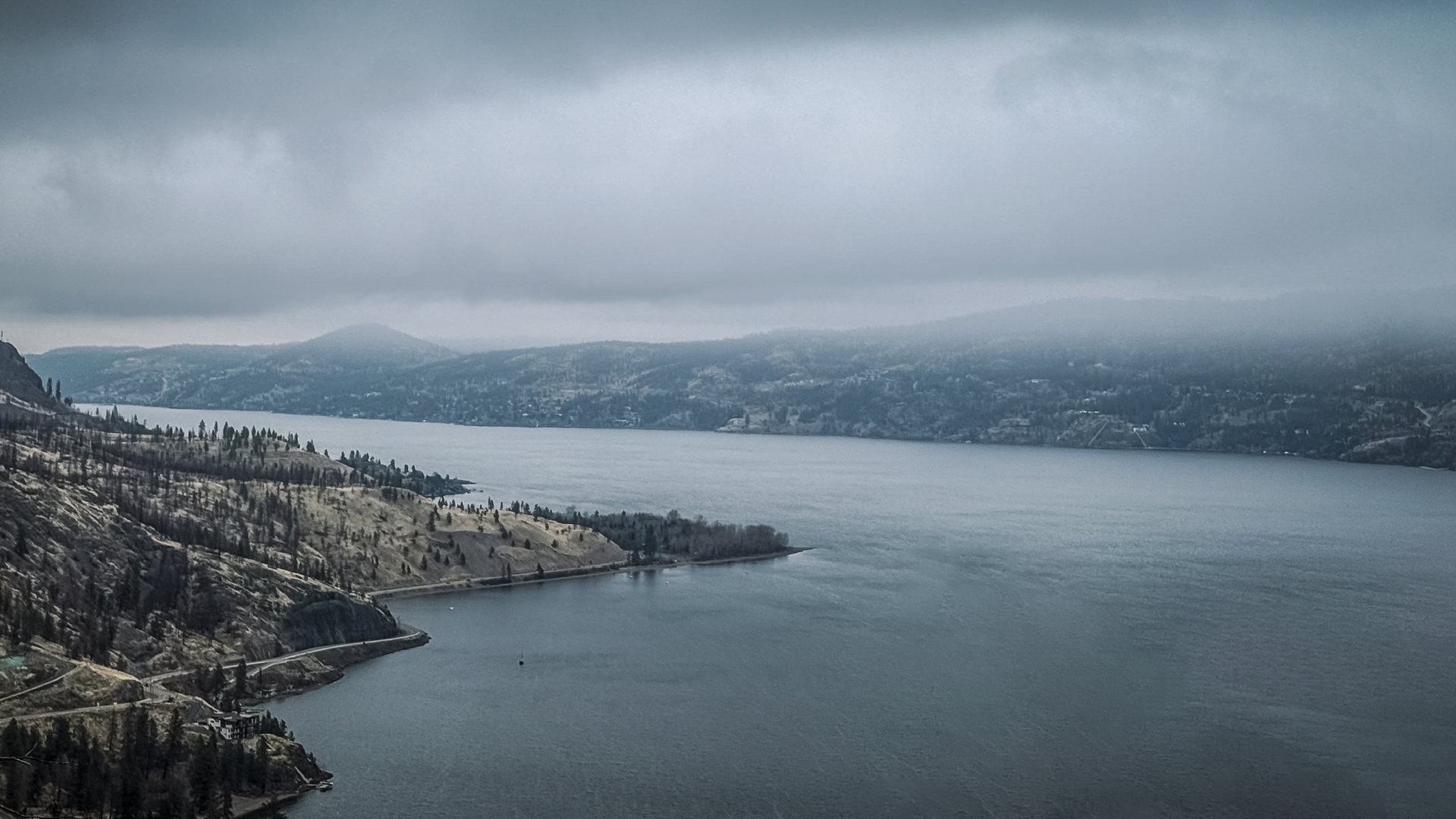 Moody overcast Okanagan lake with distant mountains fading into haze